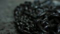 Close up for black chains made of iron in the workshop and industrial background of different machine tools. A pile of Royalty Free Stock Photo