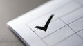 Close-up of a black checkmark in a checkbox on a white paper form with grid lines and textured surface Royalty Free Stock Photo