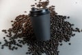 Black coffee cup in coffee beans on white background.