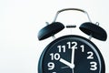 Close up of black color vintage alarm clock on white wall, time Royalty Free Stock Photo