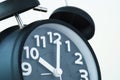 Close up of black color vintage alarm clock on white wall, time Royalty Free Stock Photo