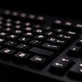 Close-up of a black computer keyboard featuring highlighted backlit keys. The keys have a standard Royalty Free Stock Photo