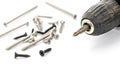 Close-up of a Black Cordless Drill Next to Assorted Screws on White Background Royalty Free Stock Photo
