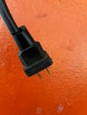 Close up black electric cable isolated on orange wall background. Royalty Free Stock Photo