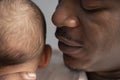 Close up, black father holding mulatto baby. Mixed race family concept