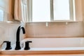 Close up of the black gooseneck faucet on the rim of a bathtub inside bathroom Royalty Free Stock Photo