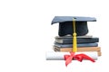 Close up black graduation cap and certificate paper with red ribbon on a stack of vintage books isolated on white background. Royalty Free Stock Photo