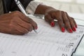 Close-up Of black hands Writing Schedule In Calendar Diary Royalty Free Stock Photo