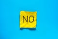 Close up black handwritten inscription no word on one yellow square sticker on blue background with copy spase, horizontal Royalty Free Stock Photo