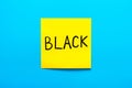 Close up black handwritten inscription black on one yellow square sticker on blue background with copy spase