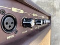 Close-up black knob, brown panel vintage acoustic combo amplifier.