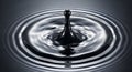 Close-up of a black liquid drop creating ripples on a dark, reflective surface. Royalty Free Stock Photo