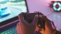 Close up of black man hands holding joystick and playing video game on the laptop