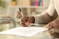 Black man hands signing document on a desk at home Royalty Free Stock Photo