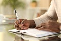 Black man hands writing reminder on agenda Royalty Free Stock Photo