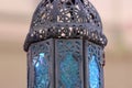 Close up of a black metal with blue stained glass Moroccan lantern