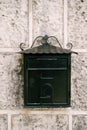 Close-up of a black metal mailbox on a stone wall. Royalty Free Stock Photo