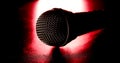Black microphone on a red light and black background Royalty Free Stock Photo