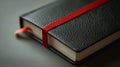 Close-up of a black notebook with a red ribbon bookmark. Royalty Free Stock Photo