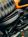 Close-up of a black and orange Yezdi scrambler motorcycle, ready to be ridden