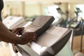 Close up of black person setting up cardio machine in gym