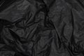 Close up of black plastic bag, The plastic surface is wrinkly and tattered making abstract pattern