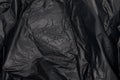 Close up of black plastic bag, The plastic surface is wrinkly and tattered making abstract pattern