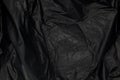 Close up of black plastic bag, The plastic surface is wrinkly and tattered making abstract pattern