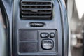 Close-up of a black plastic panel with buttons for automatically adjusting side mirrors with white markings under the air