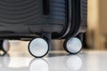 Close-up of black plastic travel carry-on suitcase on wheels