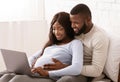 Close up of black pregnant couple using laptop at home
