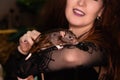 Close-up of a black rat in the hands of a witch in black clothes with disheveled hair. Halloween witch