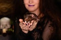 Close-up of a black rat in the hands of a witch in black clothes with disheveled hair. Halloween witch