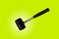 Close up black rubber mallet isolated on bright green background. Rubber hammer is a construction tool. Clipping path Royalty Free Stock Photo