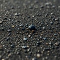 Close-up of a black sand beach, featuring smooth pebbles scattered across the Royalty Free Stock Photo