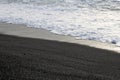 Close up of the black sand beach meeting the Pacific Ocean in Hana Bay, Hana, Maui Royalty Free Stock Photo