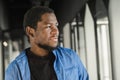 Close-up black serious male face in profile. Man stand with arms folded. Portrait of pensive african american man Royalty Free Stock Photo