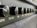 Close-up black treble knob volume on the control panel of the boutique electric guitar amplifier. clean and hi-gain distortion.