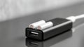 Close-up of black USB adapter with two white cylindrical batteries placed on top on reflective surface Royalty Free Stock Photo
