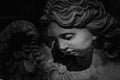 Close up black and white image of ancient statue of guardian angel Royalty Free Stock Photo