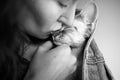 Close up, black and white photo of a woman kissing cute Devon Rex cat, love and tender mood image Royalty Free Stock Photo