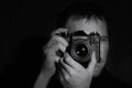 Black and white portrait of a photographer with an old camera in his hands on a dark background.horizontal frame Royalty Free Stock Photo