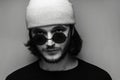 Close-up, black and white portrait of young man wearing sunglasses and hat. Royalty Free Stock Photo