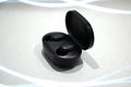 Close up of black wireless earbuds on white background
