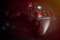 Close-up of a black wireless game controller on a dark surface with glowing buttons, symbolizing modern gaming, digital Royalty Free Stock Photo