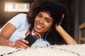 Close up black woman at home smiling with mobile phone and earphones Royalty Free Stock Photo