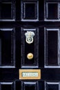 Close up of black wooden entrance door with brass letterbox in traditional style, Dublin Ireland.