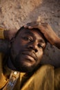 African American Man Lying on Sand in Golden Light Royalty Free Stock Photo