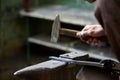 Close-up of a blacksmith`s hands manipulating a metal piece above his forge, selective focus. Royalty Free Stock Photo