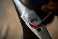 Close-up of a blacksmith`s hands manipulating a metal piece above his forge, selective focus. Royalty Free Stock Photo